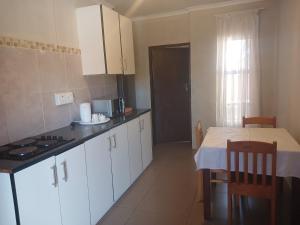 a kitchen with white cabinets and a table with a tableablish at AS contractors accommodation in Erasmus
