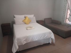 a bedroom with a bed and a chair at AS contractors accommodation in Bronkhorstspruit