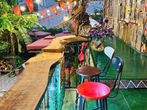 a bar with two stools and a counter with plants at Cozy Haven in Yên Bái
