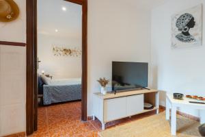 a living room with a tv and a mirror at Casa Catalán in Carmona
