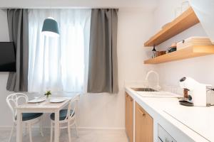 a kitchen with a table and chairs and a window at T Junior Luxury Suite in Koroni
