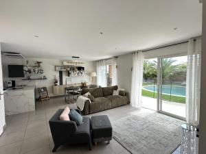 a person laying on a couch in a living room at Villa ROSÉA DU VAR in PACA Piscine Privée 10mn de Fréjus in Puget-sur Argens