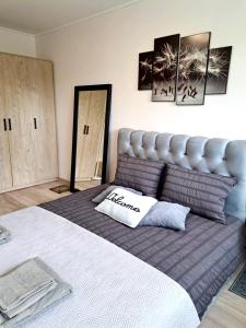 a bedroom with a large bed with a pillow on it at Ąžuolų giraitėje 2 bedroom apartments in Klaipėda