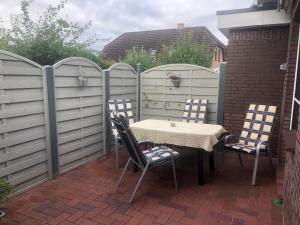 a patio with a table and chairs and a fence at Ferienwohnung "Fehn-Moor" 95156 in Rhauderfehn