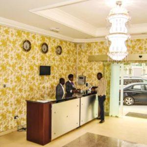 Un gruppo di uomini in piedi al bancone in una stanza di Royal Jatoz Hotel and Suites a Lagos