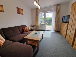 a living room with a couch and a coffee table at Ferienwohnung "Fehn-Moor" 95156 in Rhauderfehn