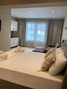 Una cama blanca grande en una habitación con sala de estar. en Locanda Dei Sogni Originale, en Othonoí