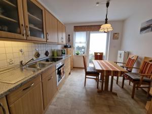 a kitchen with a sink and a table with a dining room at Ferienwohnung "Fehn-Moor" 95156 in Rhauderfehn +10 photos