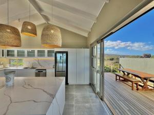 Una cocina con mesa y vista al mar. en Gratitude, en Struisbaai