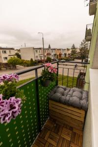 a balcony with a bench and flowers on it at Hexagon Studio Comfort in Gdańsk