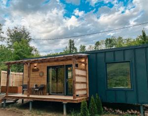 a tiny house with a deck and a table at Elysian Fields - Amber Tiny House in Sadu +15 photos