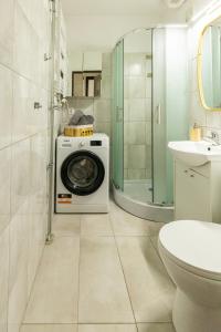 a washing machine in a bathroom with a toilet and a sink at Hexagon Studio Comfort in Gdańsk +20 photos