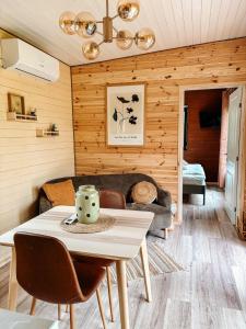 a living room with a table and a couch at Elysian Fields - Amber Tiny House in Sadu