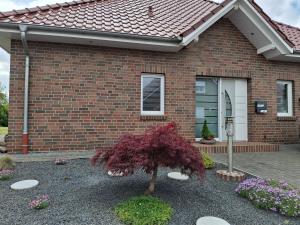 a brick house with a tree in front of it at Ferienwohnung "Haus Peter" 65357 in Moormerland