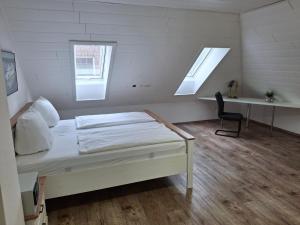 a white room with a bed and a desk at Ferienwohnung "Haus Peter" 65357 in Moormerland