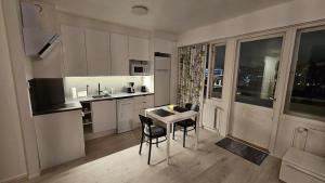 een keuken met een tafel en stoelen in een kamer bij Spacious studio with cathedral views in Turku