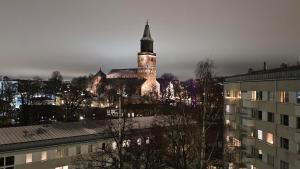 een gebouw met een klokkentoren in een stad 's nachts bij Spacious studio with cathedral views in Turku