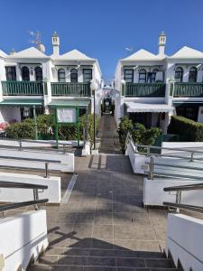 a row of white houses with benches in front of them at Bungalow Faro y Dunas Maspalomas in Maspalomas
