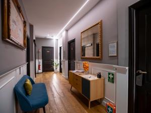 a hallway with a desk and a blue chair at Jb Relais Luxury in Rome