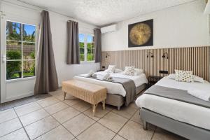a hotel room with two beds and a window at Hôtel La Nartelle in Sainte-Maxime +133 photos