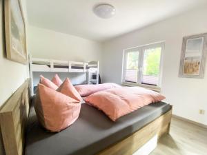 une chambre avec un lit avec des oreillers roses dans l'établissement Landhaus Kreitlow, à Ribnitz-Damgarten