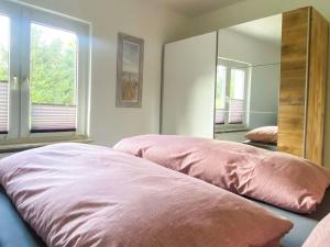 - une chambre avec 2 lits roses et un miroir dans l'établissement Landhaus Kreitlow, à Ribnitz-Damgarten 9 autres photos