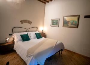 a bedroom with a large white bed with green pillows at Cosimo Charme in Chianti in Barberino di Val dʼElsa