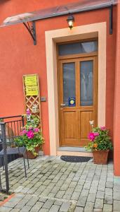 a house with a wooden door and some flowers at Casa Vacanze La Stele in Castelmonte