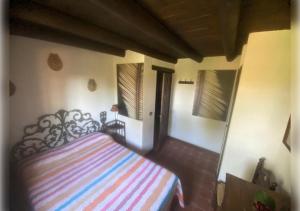 a bedroom with a bed with a colorful striped blanket at EL PUEBLO III -venga al pueblo- in Calañas +4 photos