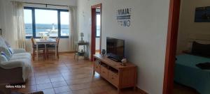 a living room with a couch and a tv and a table at APARTAMENTO ALEGRANZA in Orzola