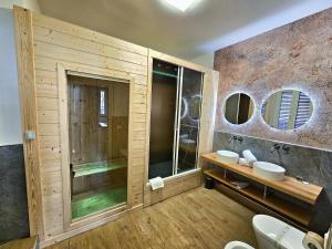 a bathroom with two sinks and a shower with mirrors at Alma Suites - Il Nido d'Amore in Livorno +18 photos