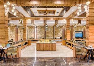 a large room with tables and chairs and a television at Corbett Elegant Retreat in Rāmnagar +57 photos