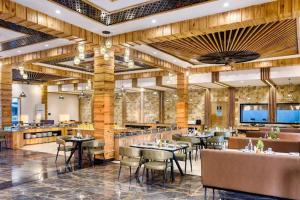 a restaurant with tables and chairs in a room at Corbett Elegant Retreat in Rāmnagar