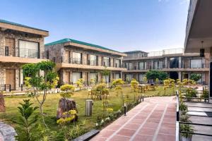 a building with a garden in the middle of a courtyard at Corbett Elegant Retreat in Rāmnagar