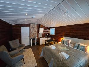 a bedroom with a bed and chairs in a room at North Frontier Studio Cabin in Saariselka