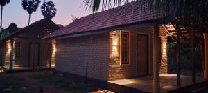 a small house with lights on the side of it at Raavan Vilage in Kadduvan
