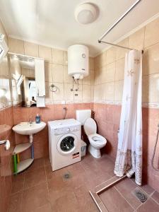 a bathroom with a toilet and a washing machine at B&V apartmani in Šušanj +34 photos