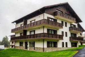 an apartment building with a gambrel roof at Alpine Nest Grand Chalet in Poiana Brasov