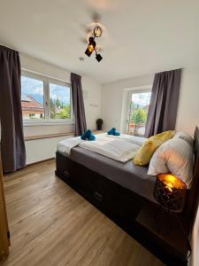 a bedroom with a large bed with two windows at Uii Apartments Oberaudorf in Oberaudorf