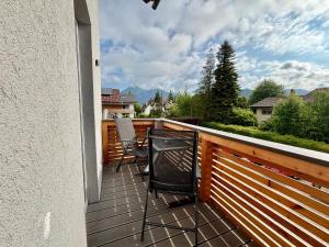 a balcony with a table and chairs on a deck at Uii Apartments Oberaudorf in Oberaudorf
