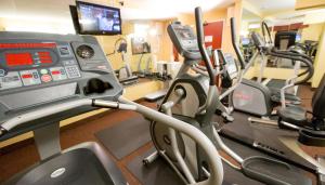 a gym with several tread machines and a tv at The Portlander Inn and Marketplace in Portland +37 photos