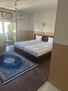 a bedroom with a large bed and a rug at Комлекс Кристо in Blagoevgrad