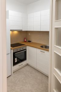 a kitchen with white cabinets and a sink at Casa Verde LLS in Budva
