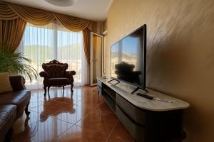 a living room with a tv and a couch at Casa Verde LLS in Budva