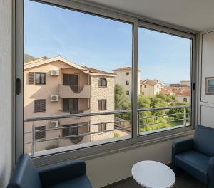 a room with two chairs and a large window at Casa Verde LLS in Budva
