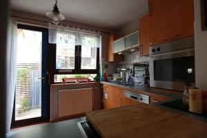 a kitchen with wooden cabinets and a large window at Maison Marie in Ubstadt-Weiher