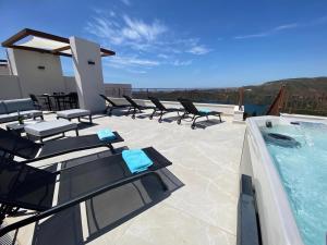 a patio with lounge chairs and a swimming pool at Modern penthouse with two terraces, jacuzzi and sea, lake and mountain views, in Almazara Hills in Istán +41 photos