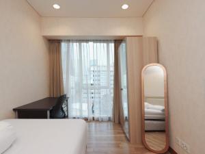 a bedroom with a mirror and a bed and a desk at Luxury 2BR Apartment in Setiabudi Skygarden in Jakarta +15 photos