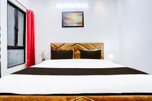 a bedroom with a large white bed and a window at Hotel O Virat Inn in Lucknow