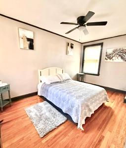 シカゴにあるQuiet 1BR, Eat-In Kitchen, Close to Midwayのベッドと天井扇風機のある寝室